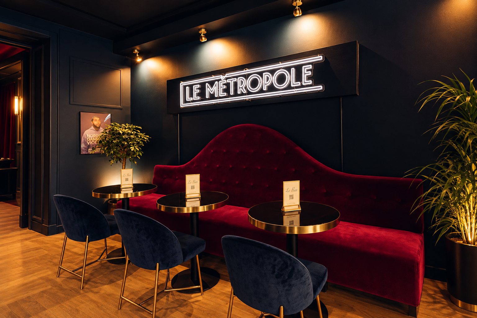 The bar at Le Métropole, red velvet banquette beneath the neon sign